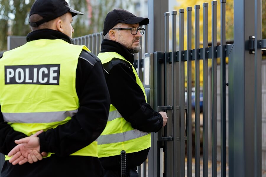 Two policemen standing in the front gate of the house