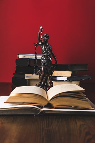 Justice statue with law books on a table