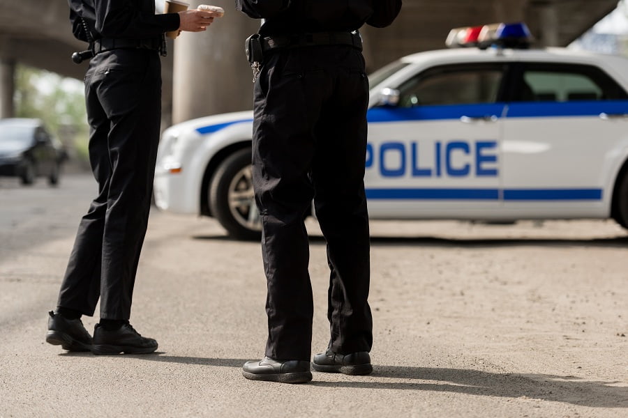 Police officers and a police car on the road