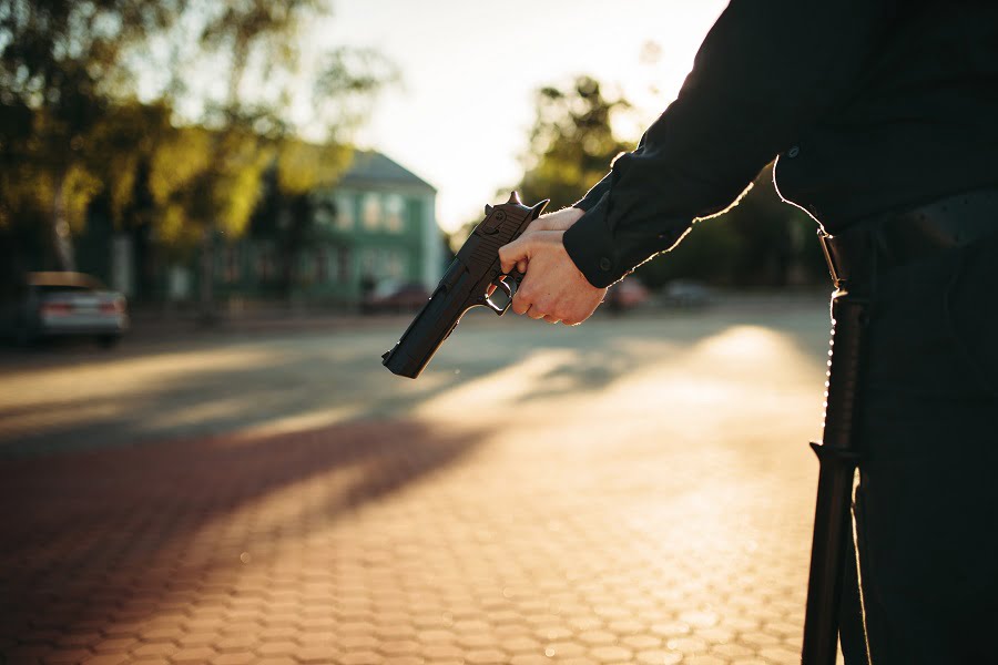 Male cop in uniform holding a gun