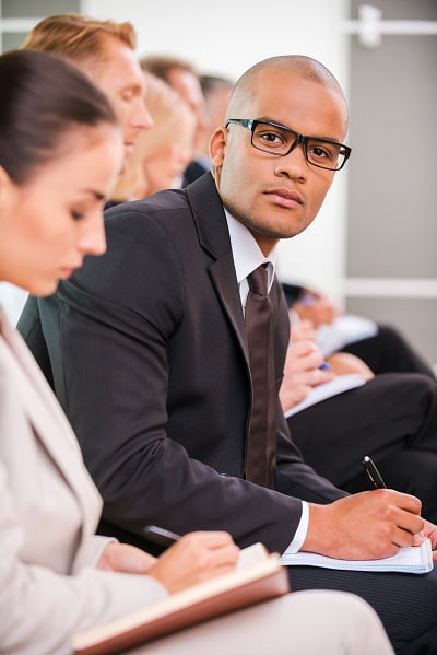 Men and women in suit attending an orientation