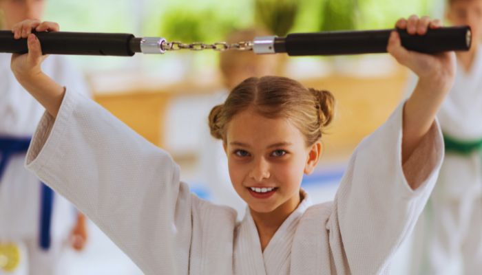 Girl in Karate rope holding the Nunchucks